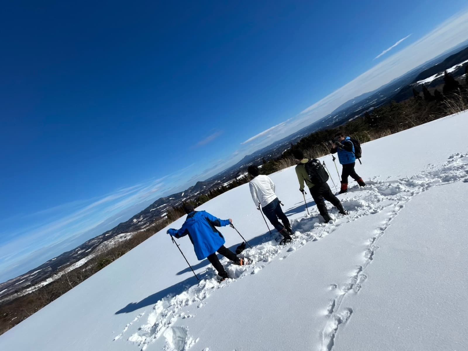 Snowshoe hiking under a deep blue sky